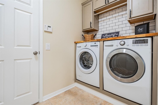 washroom featuring light tile patterned floors, cabinets, and washing machine and clothes dryer