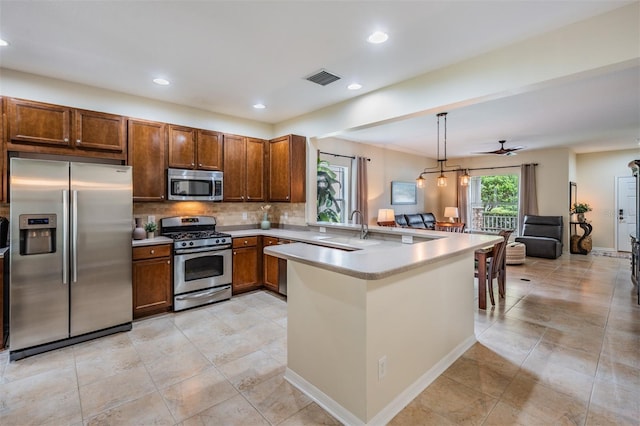 19308 Sunset Bay Dr, Land O Lakes, FL 34638 - kitchen featuring stainless steel appliances, a peninsula, open floor plan, a sink, and decorative backsplash