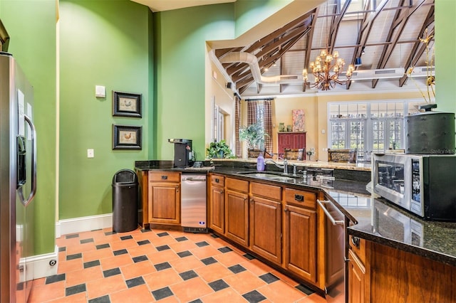 19308 Sunset Bay Dr, Land O Lakes, FL 34638 - kitchen featuring stainless steel appliances, a sink, a chandelier, brown cabinetry, and high vaulted ceiling