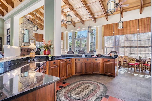 19308 Sunset Bay Dr, Land O Lakes, FL 34638 - kitchen with ornate columns, wood ceiling, stone tile floors, beamed ceiling, and a ceiling fan