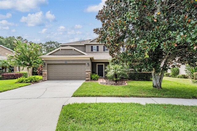 19308 Sunset Bay Dr, Land O Lakes, FL 34638 - view of front of home featuring stucco siding, a front yard, an attached garage, stone siding, and concrete driveway