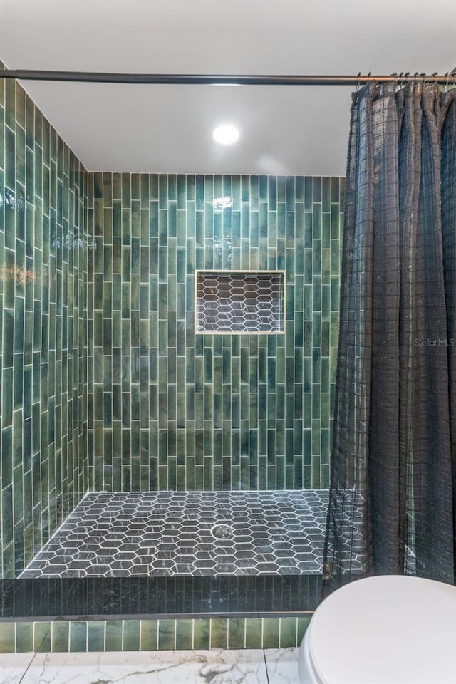 bathroom with curtained shower and toilet