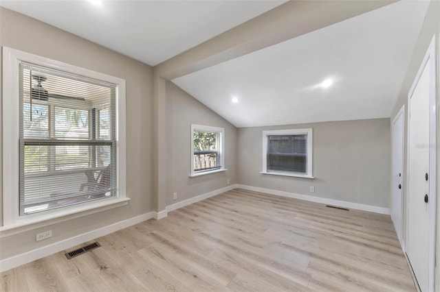 spare room with lofted ceiling and light hardwood / wood-style flooring