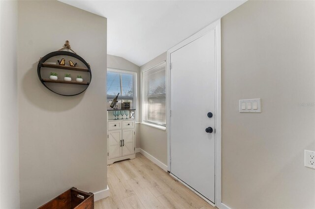 entryway with lofted ceiling and light wood-type flooring