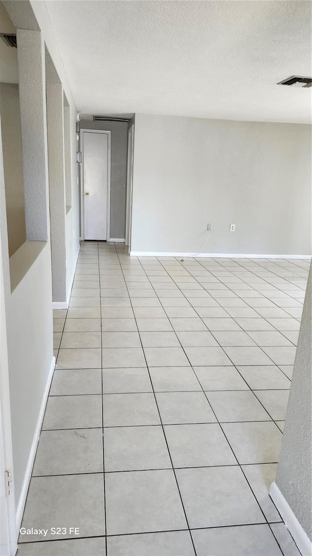 tiled spare room featuring a textured ceiling