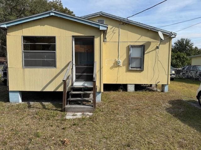 rear view of house featuring a yard