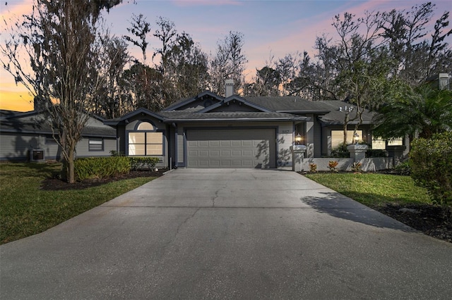 single story home with a garage and a lawn