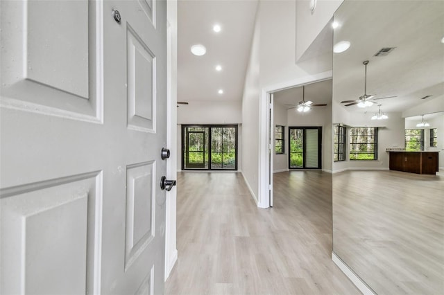 entryway with a towering ceiling and light hardwood / wood-style floors