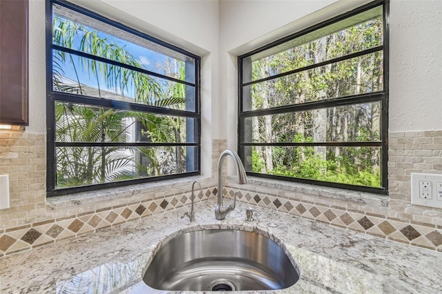 interior details featuring light stone countertops and indoor wet bar