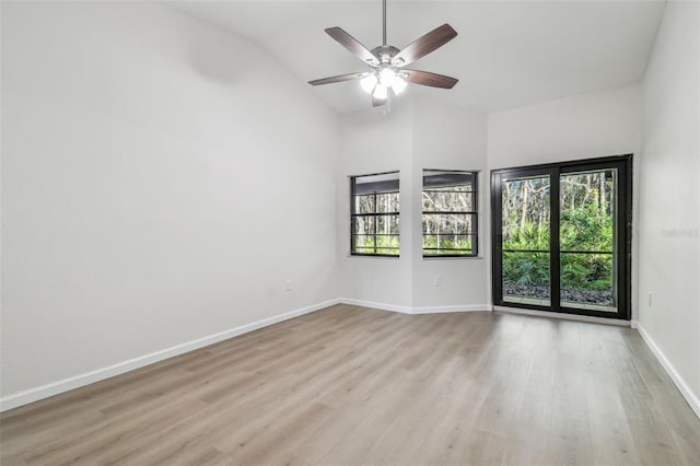 spare room featuring ceiling fan, lofted ceiling, and light hardwood / wood-style flooring