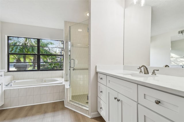 bathroom featuring vanity, separate shower and tub, and hardwood / wood-style floors