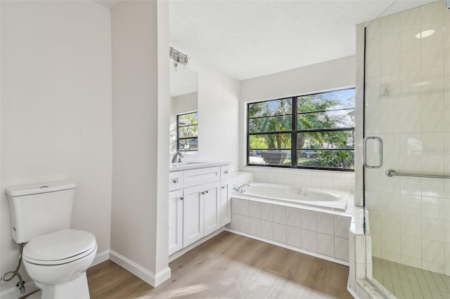 full bathroom featuring vanity, hardwood / wood-style flooring, shower with separate bathtub, and toilet