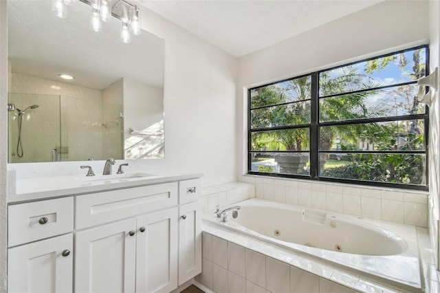 bathroom with vanity and shower with separate bathtub