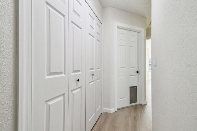 corridor with light hardwood / wood-style floors