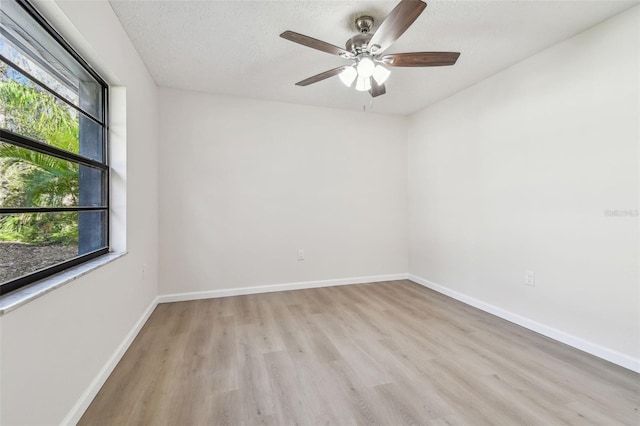 empty room featuring ceiling fan, a textured ceiling, and light wood-type flooring