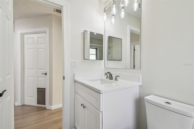 bathroom with vanity, hardwood / wood-style floors, and toilet