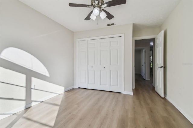 unfurnished bedroom with ceiling fan, a closet, and light hardwood / wood-style flooring