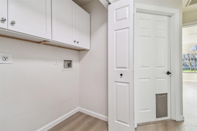 laundry area with hookup for a washing machine, cabinets, and light wood-type flooring