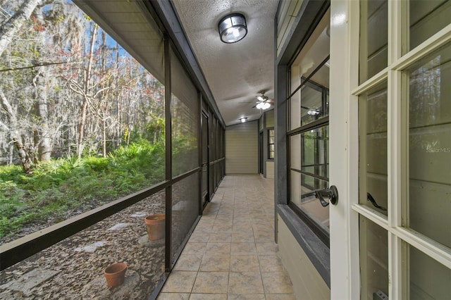 unfurnished sunroom with ceiling fan