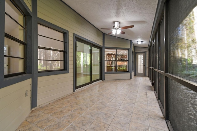 unfurnished sunroom with a wealth of natural light, ceiling fan, and vaulted ceiling