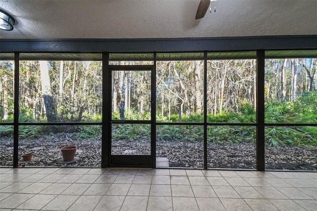 unfurnished sunroom featuring ceiling fan