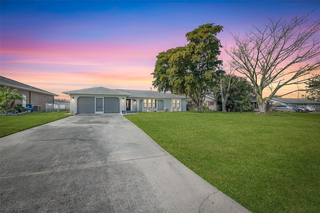 ranch-style home featuring a garage and a yard