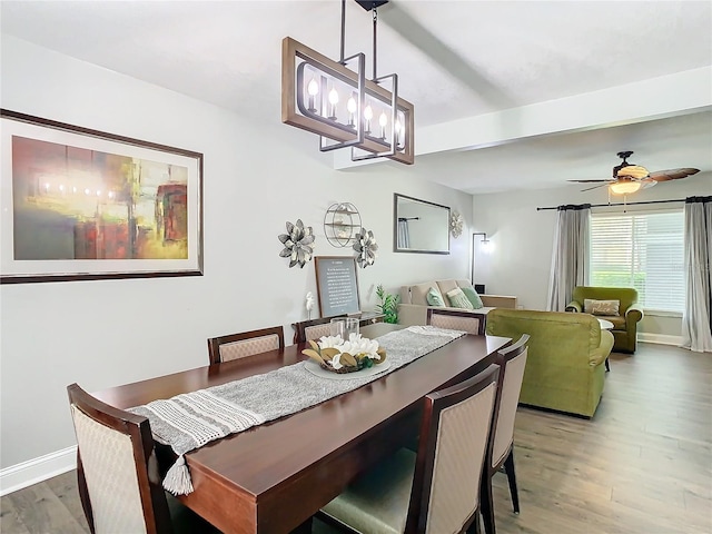 dining area with hardwood / wood-style flooring, ceiling fan, and beamed ceiling