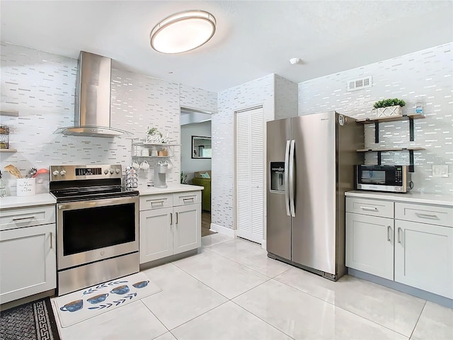 kitchen featuring wall chimney exhaust hood, stainless steel appliances, light tile patterned flooring, and backsplash