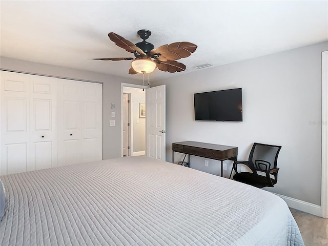 bedroom featuring light wood-type flooring, ceiling fan, and a closet