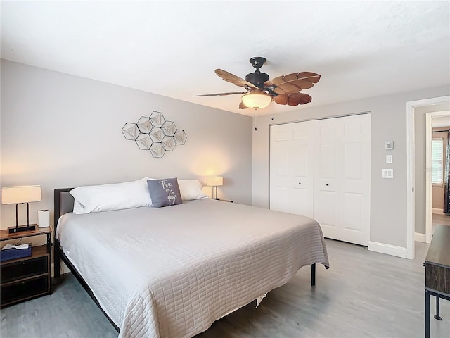 bedroom with hardwood / wood-style flooring, ceiling fan, and a closet