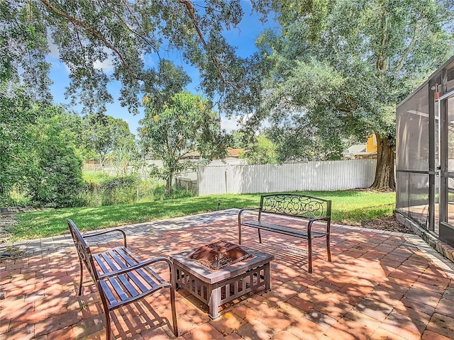 view of patio with glass enclosure and an outdoor fire pit