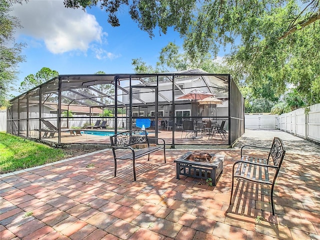 view of patio / terrace featuring a fenced in pool, a lanai, and a fire pit