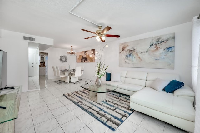 tiled living room featuring ceiling fan with notable chandelier and a textured ceiling