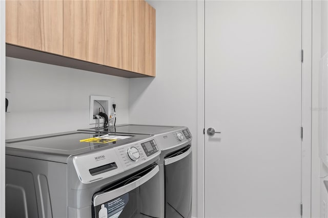 washroom featuring independent washer and dryer and cabinets