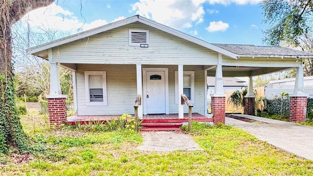 bungalow-style house featuring a front yard and covered porch