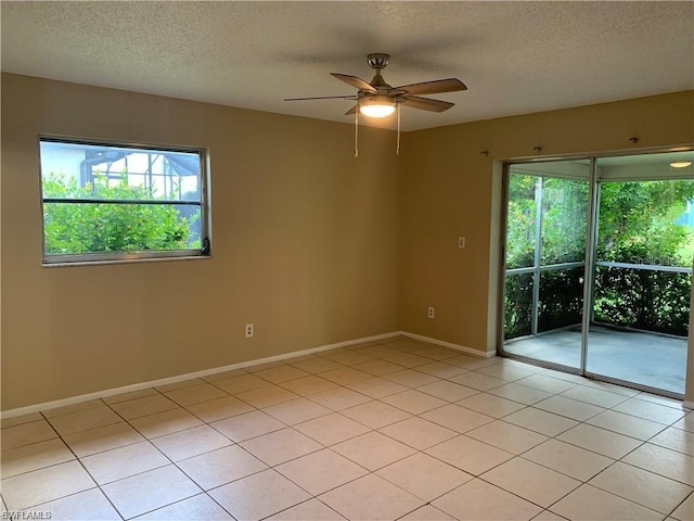 tiled spare room with ceiling fan and a textured ceiling