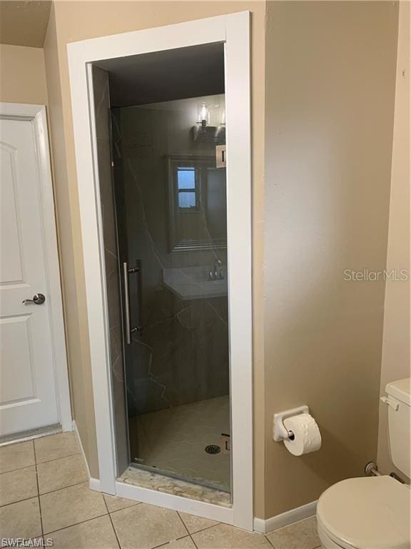 bathroom featuring tile patterned floors, toilet, and walk in shower