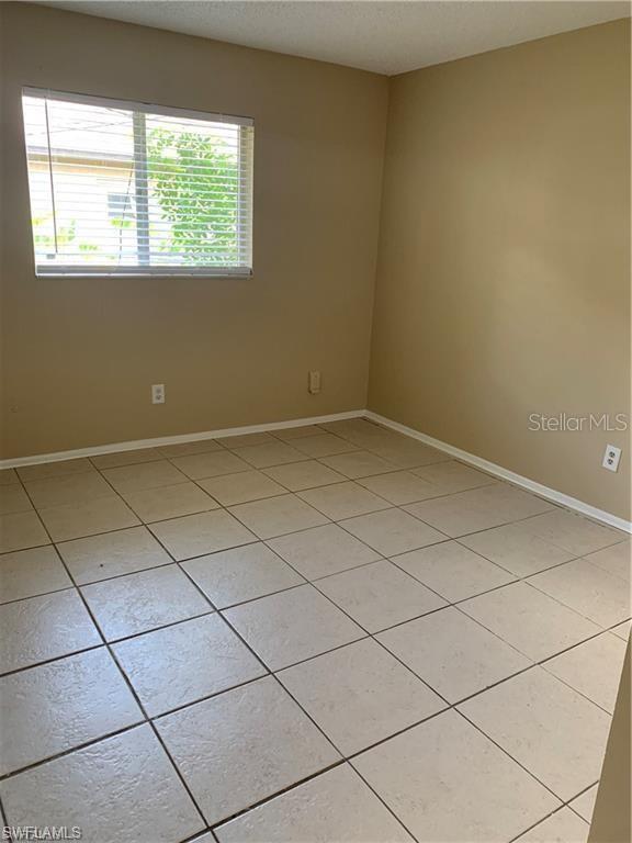 tiled spare room featuring a textured ceiling