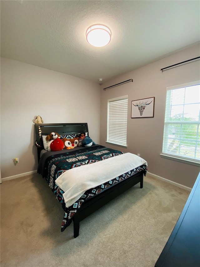 bedroom with a textured ceiling, carpet floors, and baseboards