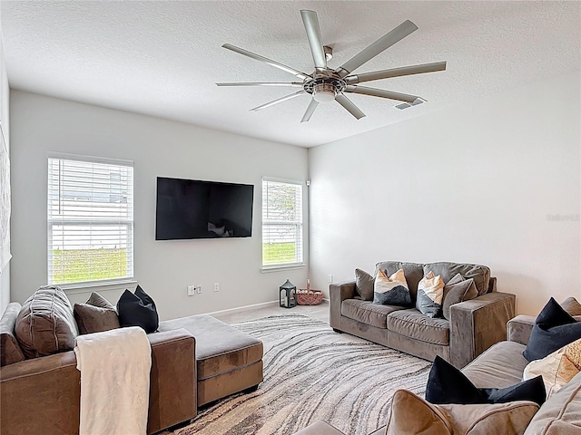 living room with visible vents, a textured ceiling, and a ceiling fan