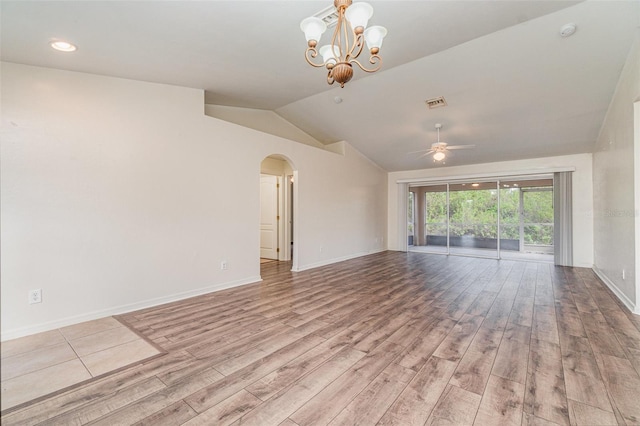 spare room with ceiling fan with notable chandelier, vaulted ceiling, and light hardwood / wood-style floors