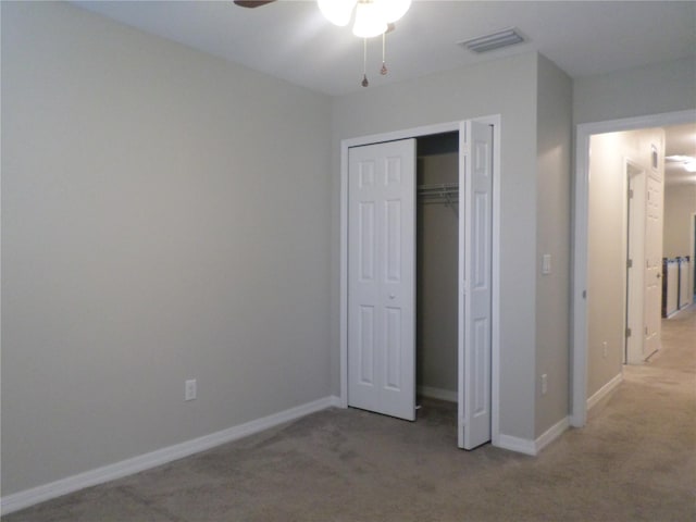 unfurnished bedroom featuring light colored carpet, ceiling fan, and a closet