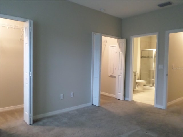 unfurnished bedroom featuring ensuite bathroom and carpet floors