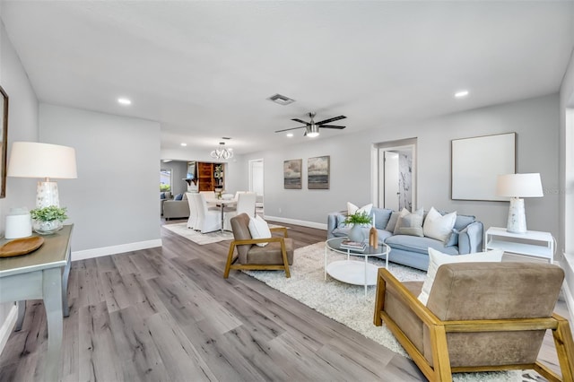 living room with ceiling fan and light hardwood / wood-style flooring