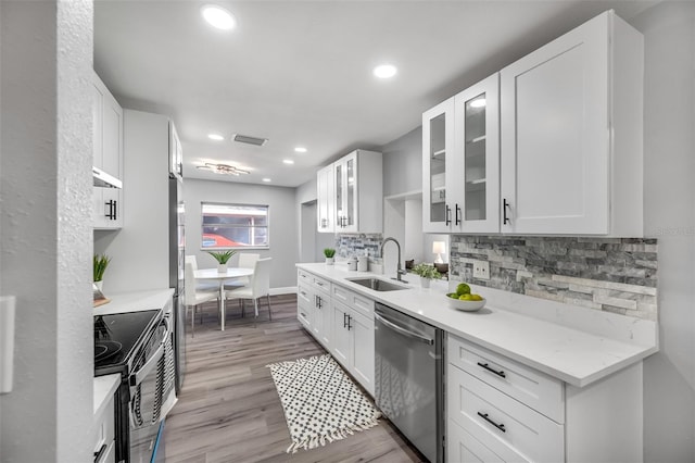 kitchen featuring white cabinetry, dishwasher, sink, and black / electric stove