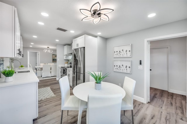 dining area featuring sink and light hardwood / wood-style flooring