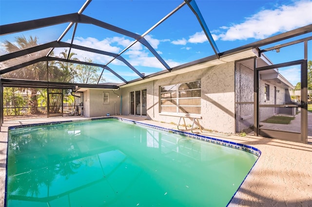 view of swimming pool featuring a patio and glass enclosure