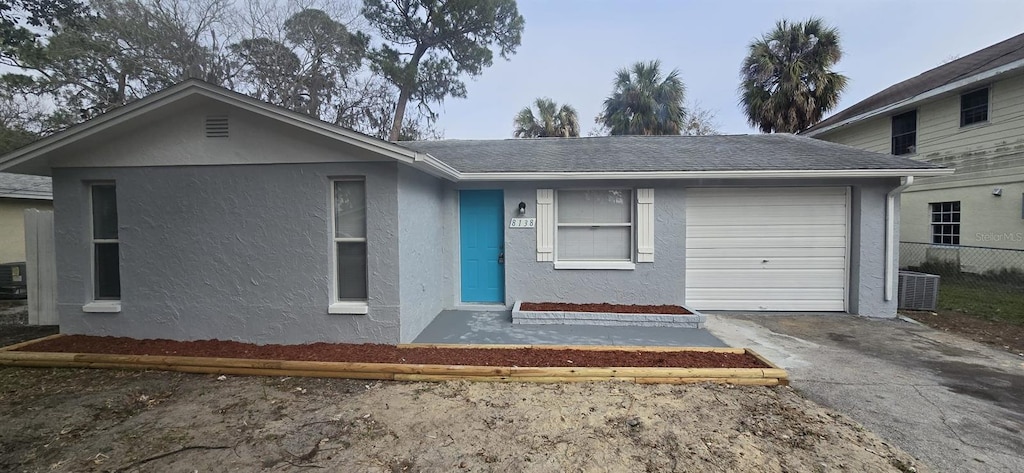 view of front of home with central AC unit and a garage