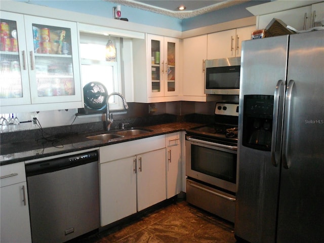 kitchen featuring white cabinetry, sink, dark stone counters, and appliances with stainless steel finishes