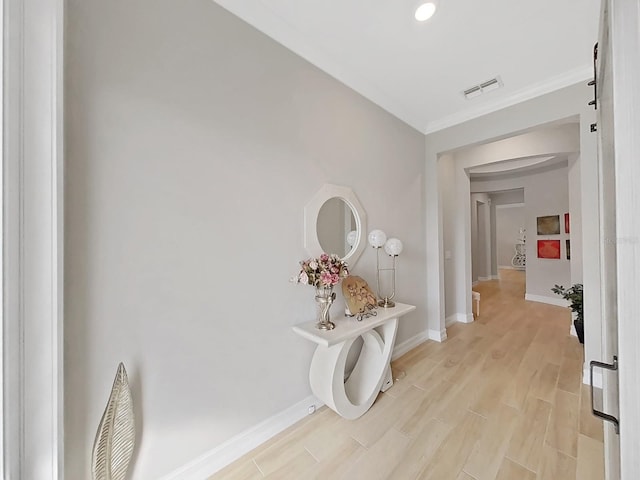 hall featuring ornamental molding and light hardwood / wood-style flooring